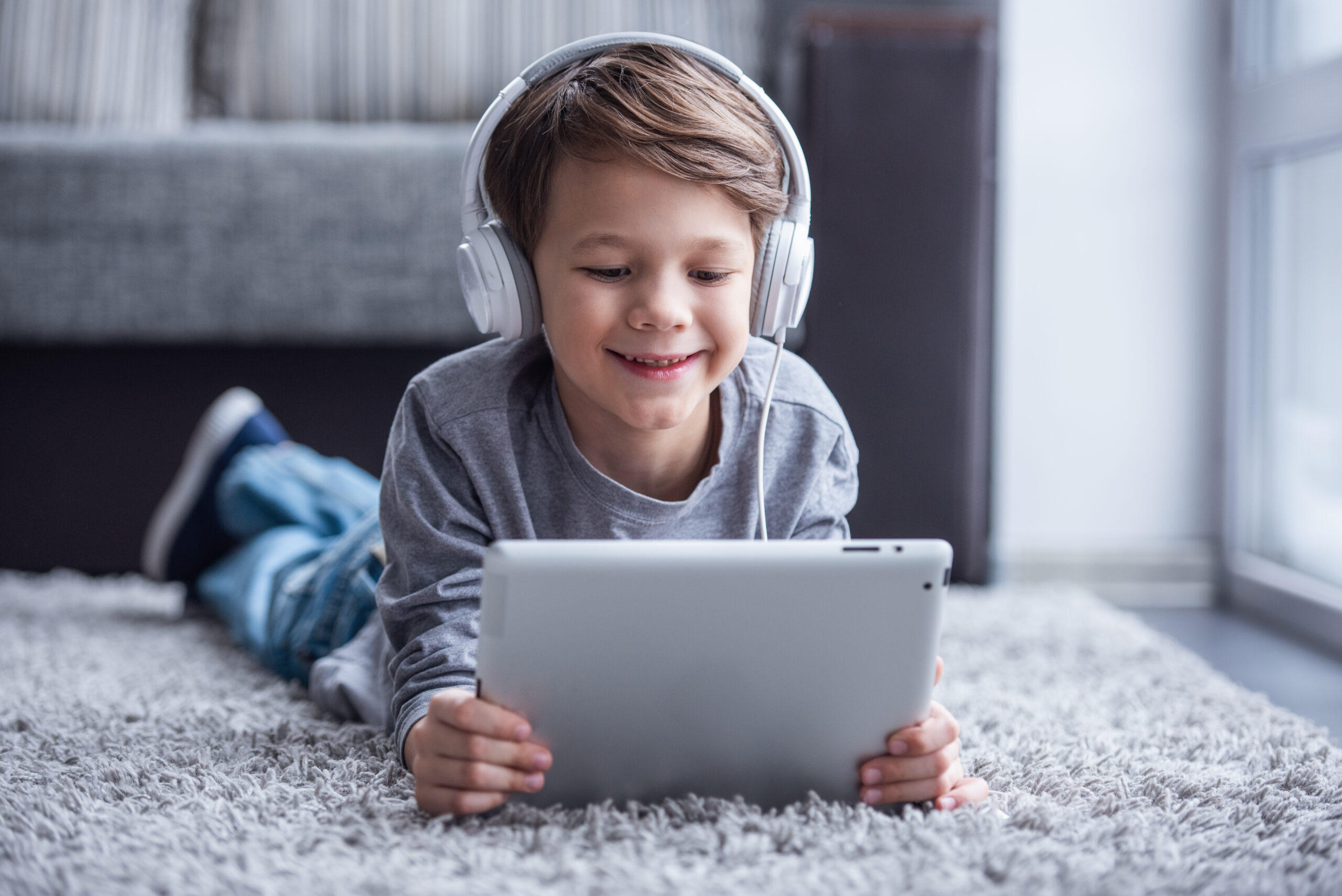 little boy with headphones on and a digital tablet
